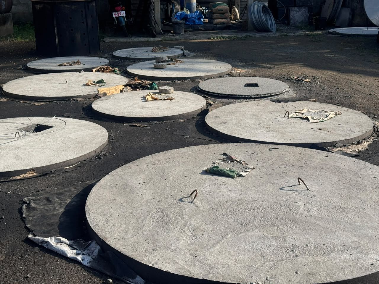 Round precast concrete cover slabs with cast-in lifting hooks
