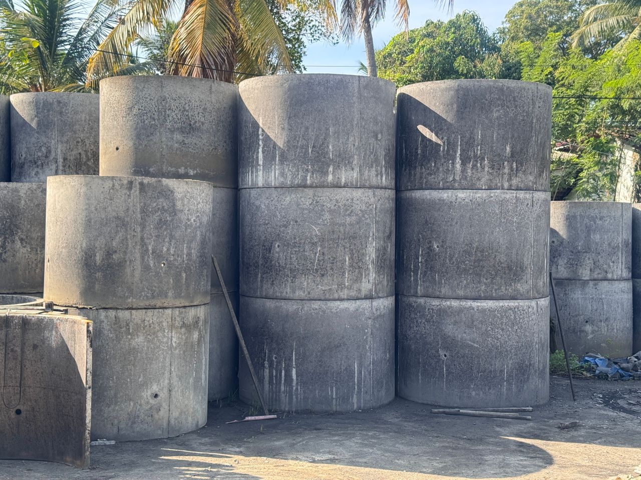 අජිත් කොන්ක්‍රීට් වර්ක්ස් වැඩපොළේ දෙක තුන බැගින් එක මත එක තබා ඇති කොන්ක්‍රීට් ළිං වළලු