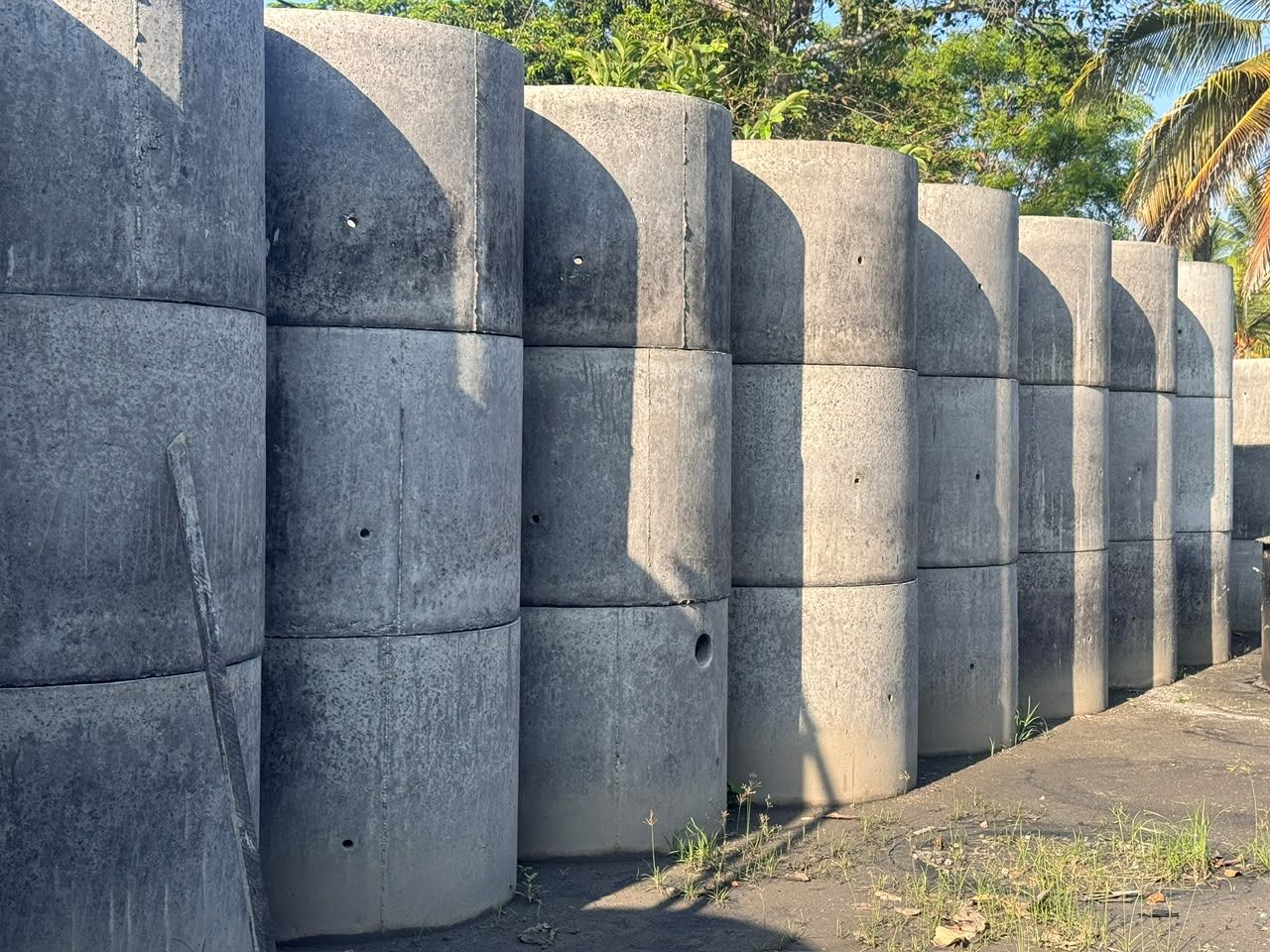 Rows of precast concrete well rings stacked three high in the Ajith Concrete yard