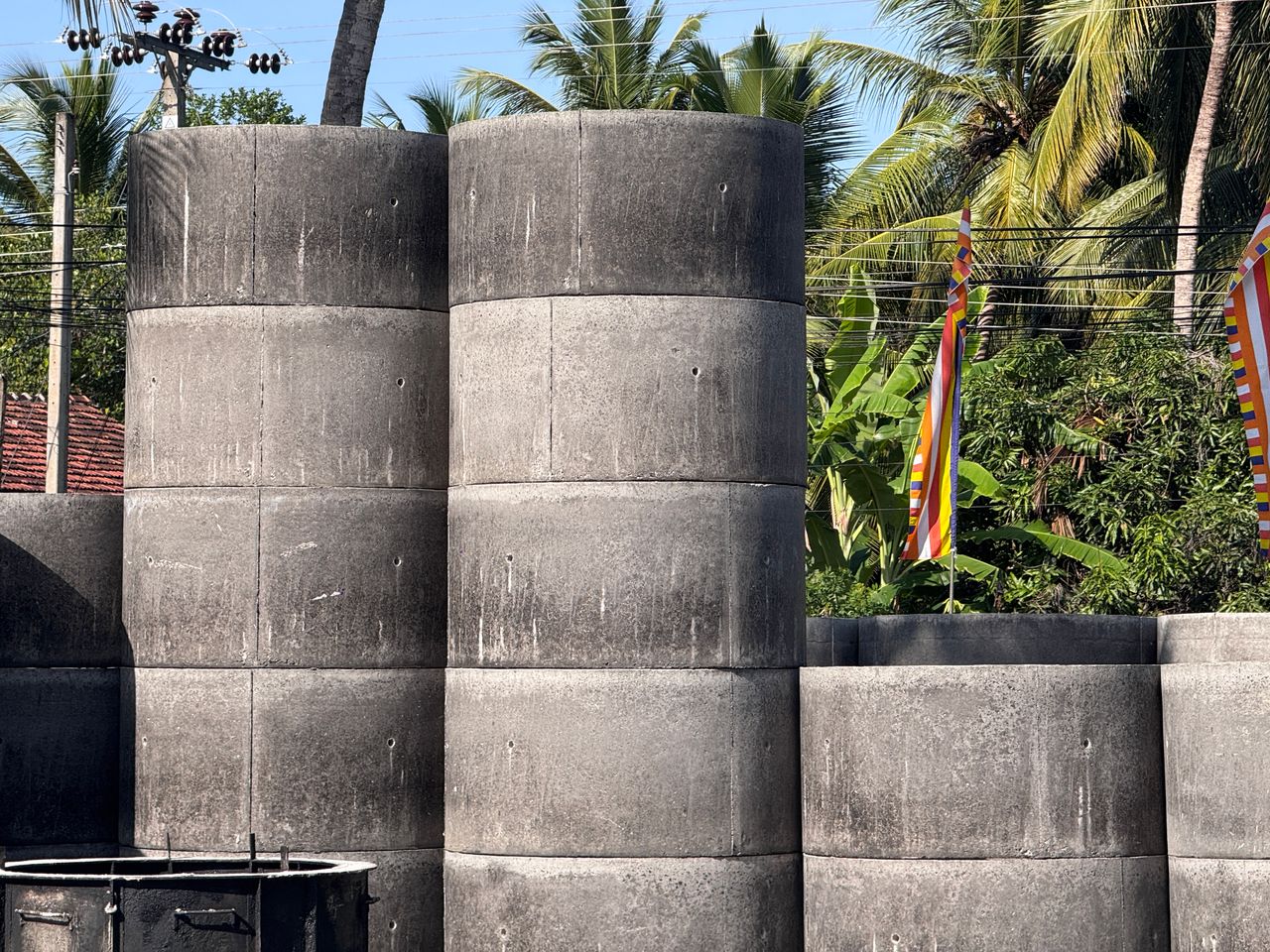 Finished concrete rings stacked five high in the Ajith Concrete Works yard, ready to load