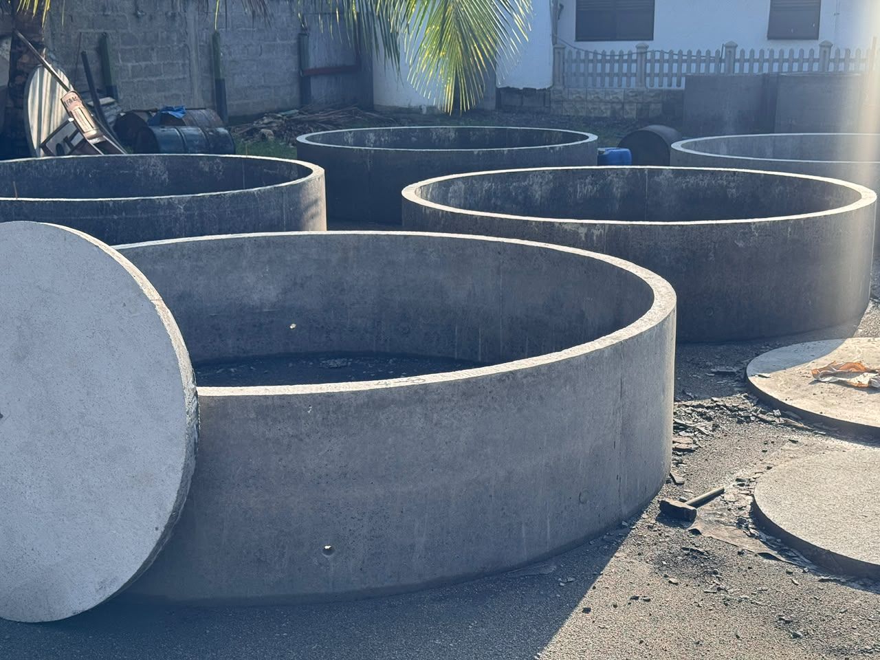 Large, shallow precast concrete rings 8 and 9 feet wide, with a cover slab leaning against one