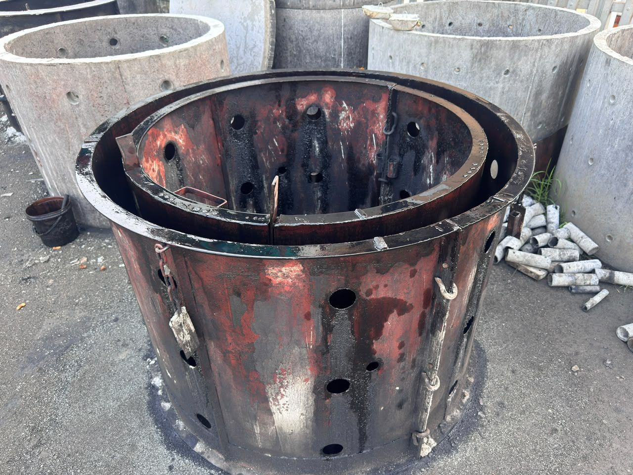 A steel mould for a perforated soakage ring, with rows of holes through both shells for the pins