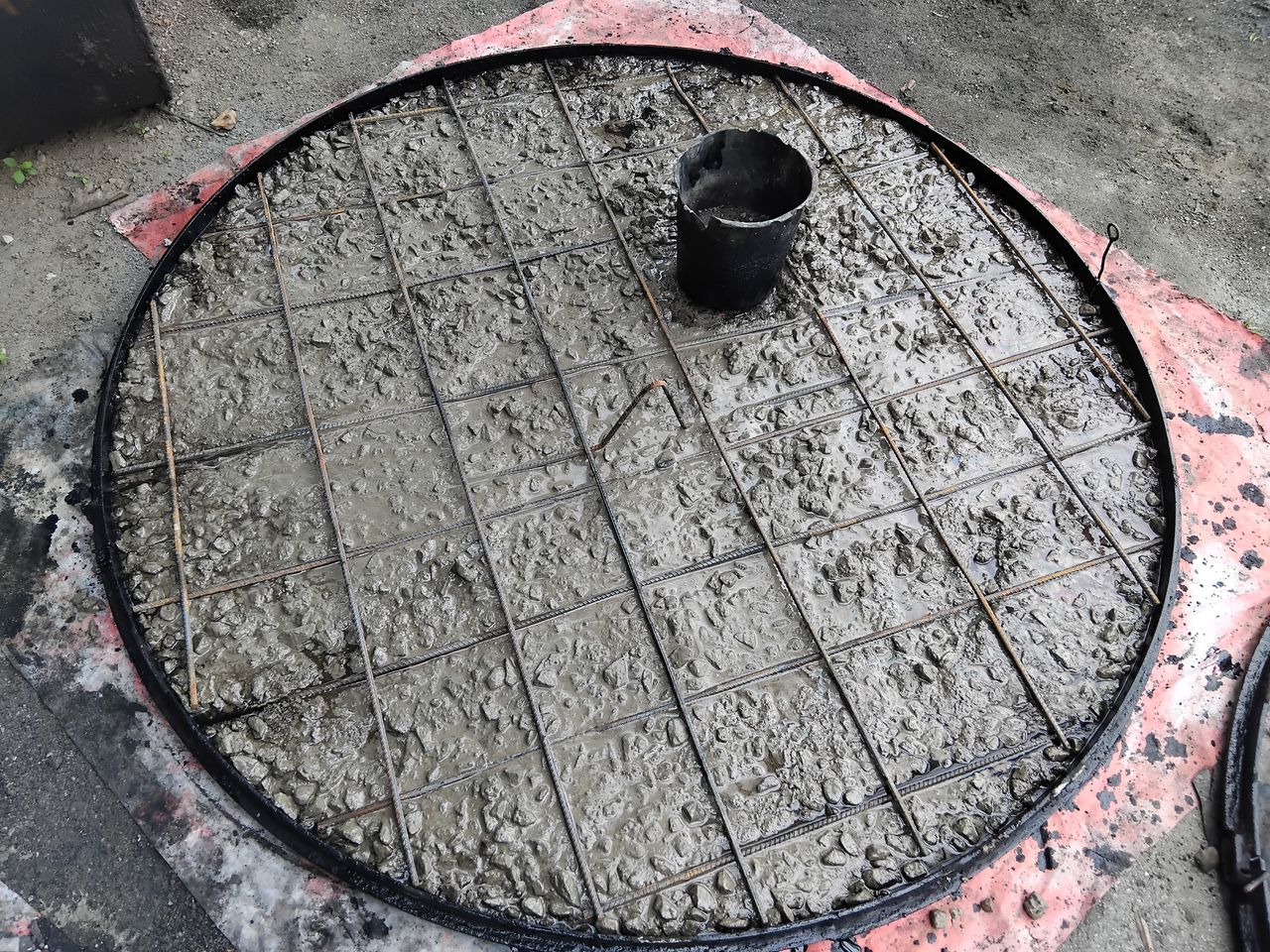 A round cover slab being cast with steel mesh and a round form set in for the opening